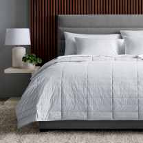 True Temp Weighted Blanket in soft rose on dressed bed that adapts to your ideal temperature throughout the night 