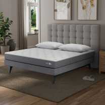 c1 smart bed mattress with gray tuffted headboard in a bedroom