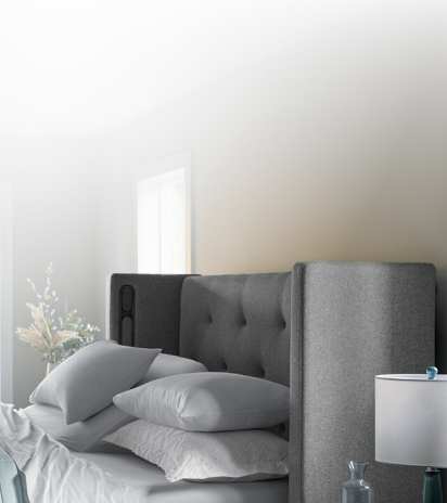 Half a front-facing Windowpane curve headboard and bed covered with Puckered stripe duvet.