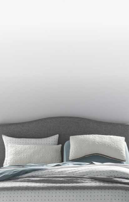 A variety of pillows in front of a STONE_300 upholstered headboard, how to choose a pillow that's right for you, link to shop all pillows
