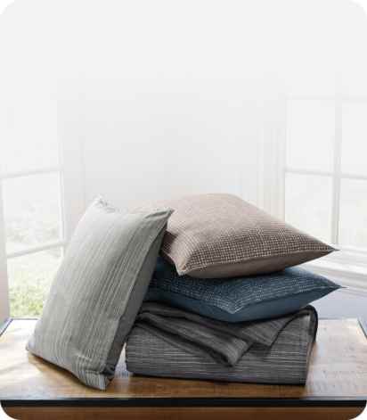 Stacked throws in a variety of different colors and patterns