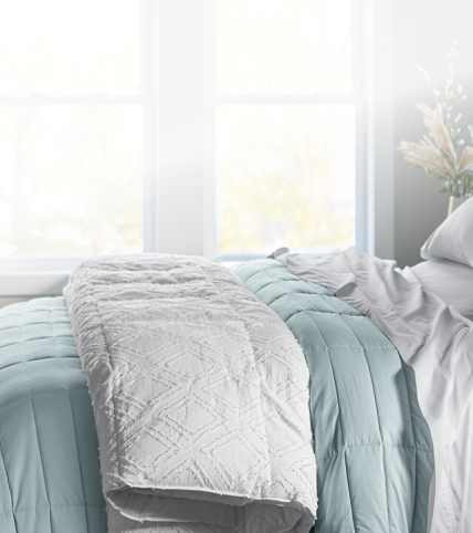 Dressed bed with blackberry plum grid stitch coverlet, clean asthetic