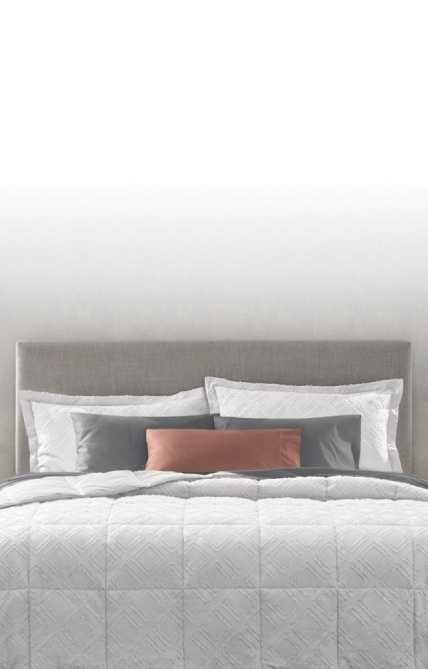 Image of head of dressed bed, Comforter vs. Duvet Guide, text reads: learn the difference and how to create a cozy, individualized retreat, link to shop now