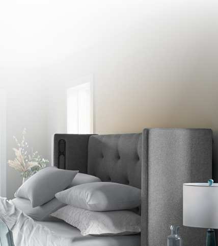 Half a front-facing Windowpane curve headboard and bed covered with Puckered stripe duvet.