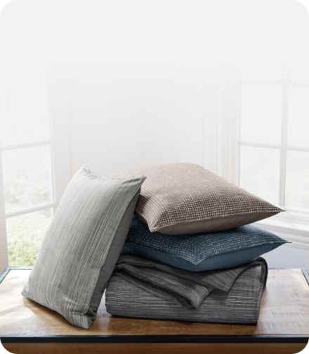 Stacked throws in a variety of different colors and patterns