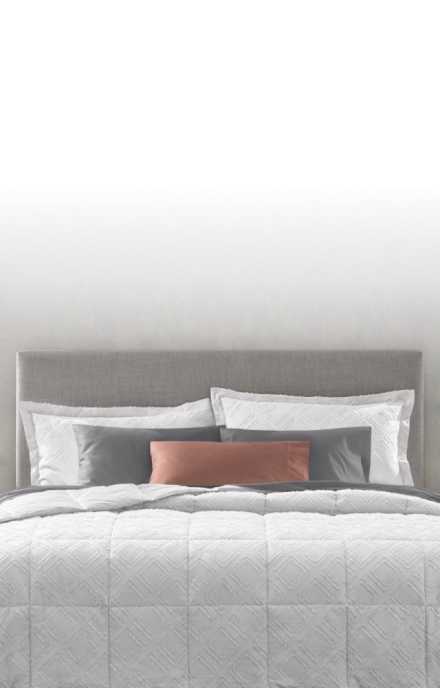 Image of head of dressed bed, Comforter vs. Duvet Guide, text reads: learn the difference and how to create a cozy, individualized retreat, link to shop now