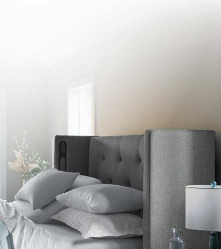 Half a front-facing Windowpane curve headboard and bed covered with Puckered stripe duvet.
