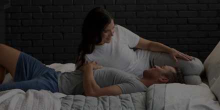 Couple sleeping under blanket