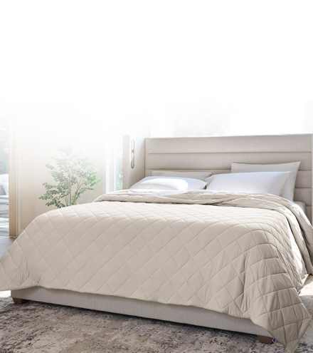 Dressed bed with blackberry plum grid stitch coverlet, clean asthetic