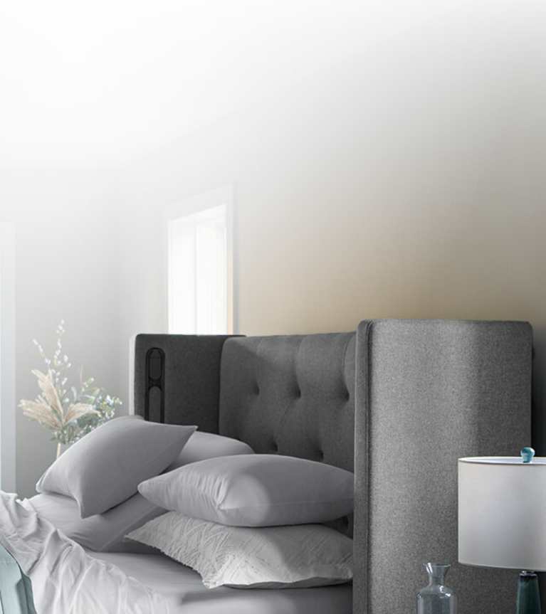 Half a front-facing Windowpane curve headboard and bed covered with Puckered stripe duvet.