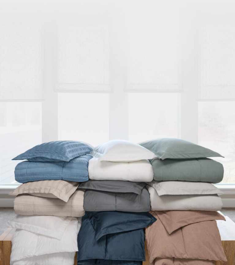 Stacked throws in a variety of different colors and patterns