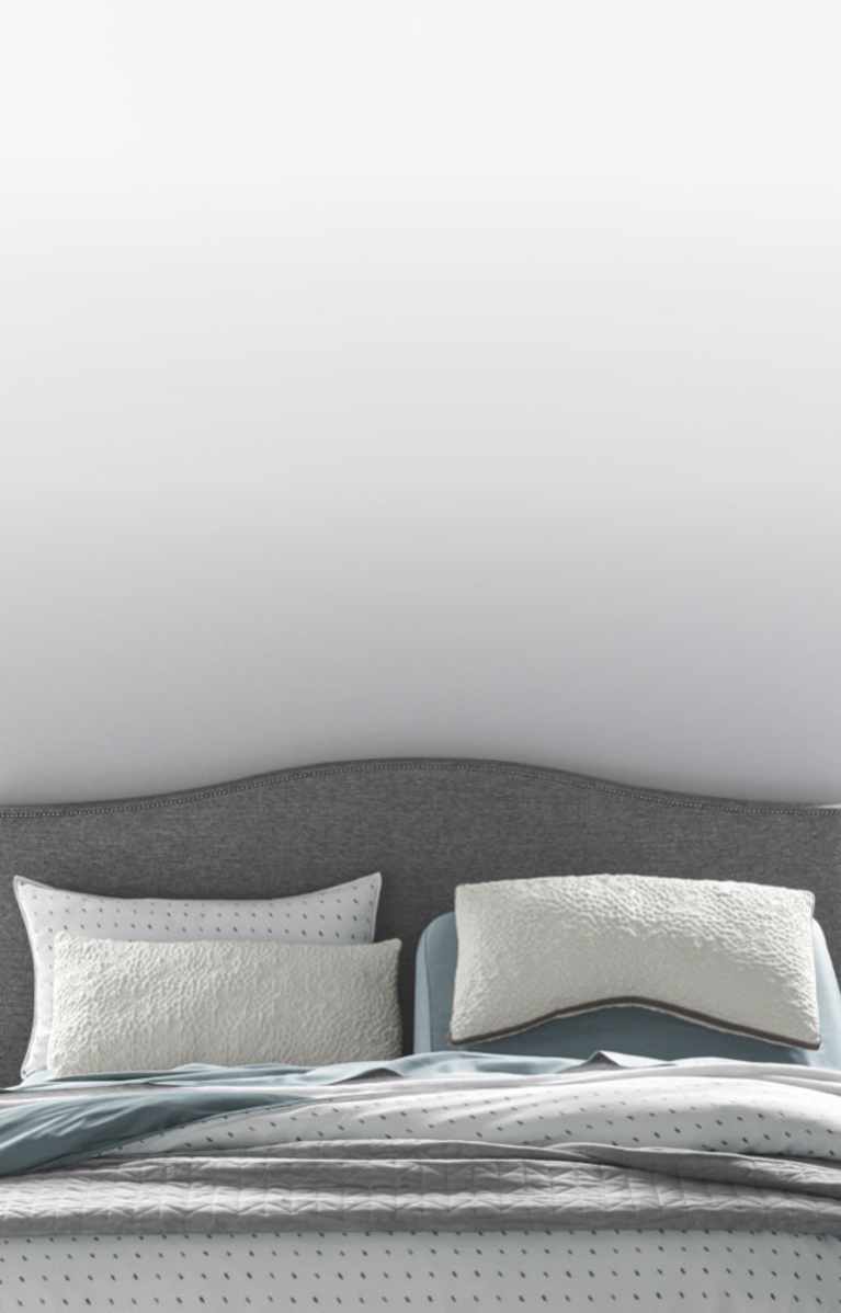 A variety of pillows in front of a STONE_300 upholstered headboard, how to choose a pillow that's right for you, link to shop all pillows