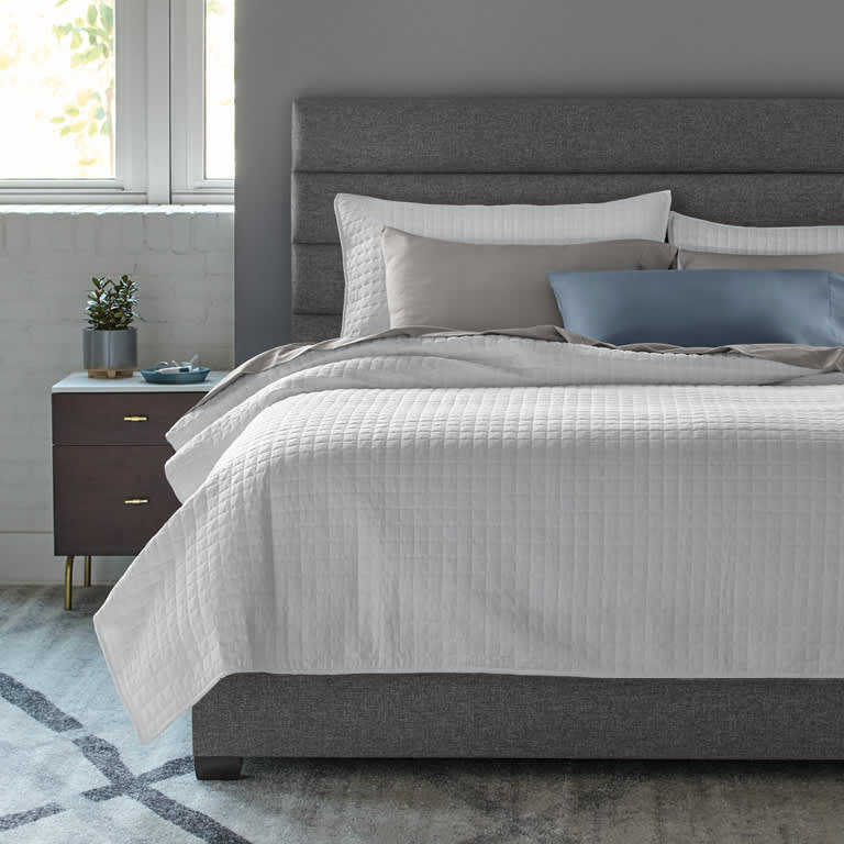 https://cdn.sleepnumber.com/image/upload/f_auto,q_auto:eco/v1665518696/workarea/catalog/product_images/grid-stitch-coverlet-set/Grid-Stitch-Coverlet_PDP_Postcard_Variant_White