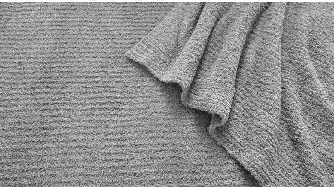 Ready to cuddle? Snuggle into luxurious softness and warmth. Detail image of Plush Blankets stacked on top of each other.