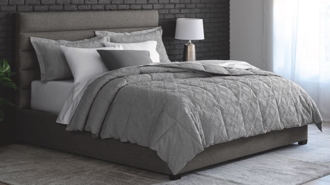 Image of dressed bed with grey comforter