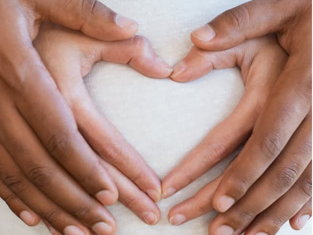 Pregnant woman with her partner holding hands