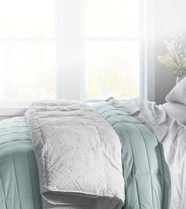 Dressed bed with blackberry plum grid stitch coverlet, clean asthetic