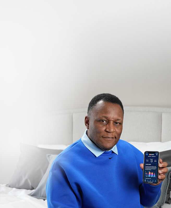 NFL Legend Barry Sanders holding a phone with BreatheIQ